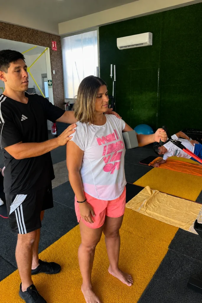 Fisioterapeuta guiando un ejercicio durante una sesión de fisioterapia activa y entrenamiento personal