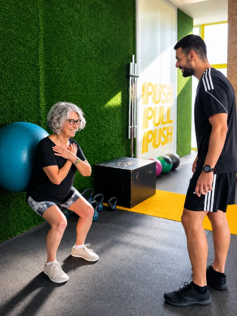 Mujer realizando una sentadilla durante una sesión de entrenamiento personal con su entrenador en Alicante Fit Corner