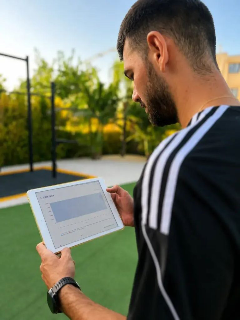 Entrenador personal analizando una evaluación de fuerza en una tablet en Alicante Fit Corner